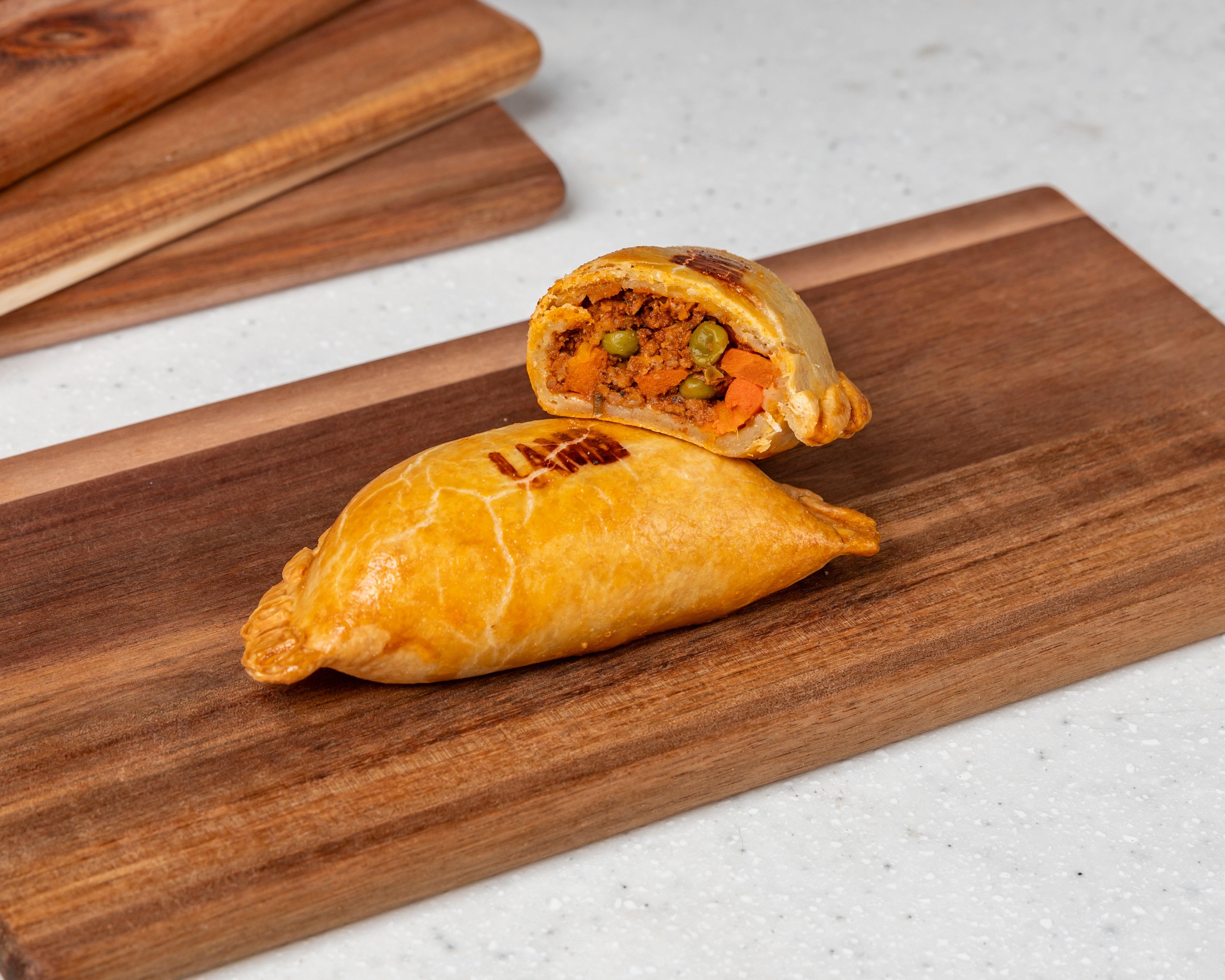 Classic Lamb Empanada filled with Aussie lamb mince, onions, tomato gravy, rosemary, baby carrots, and peas – golden pastry handmade by Cholito Empanadas in Sydney