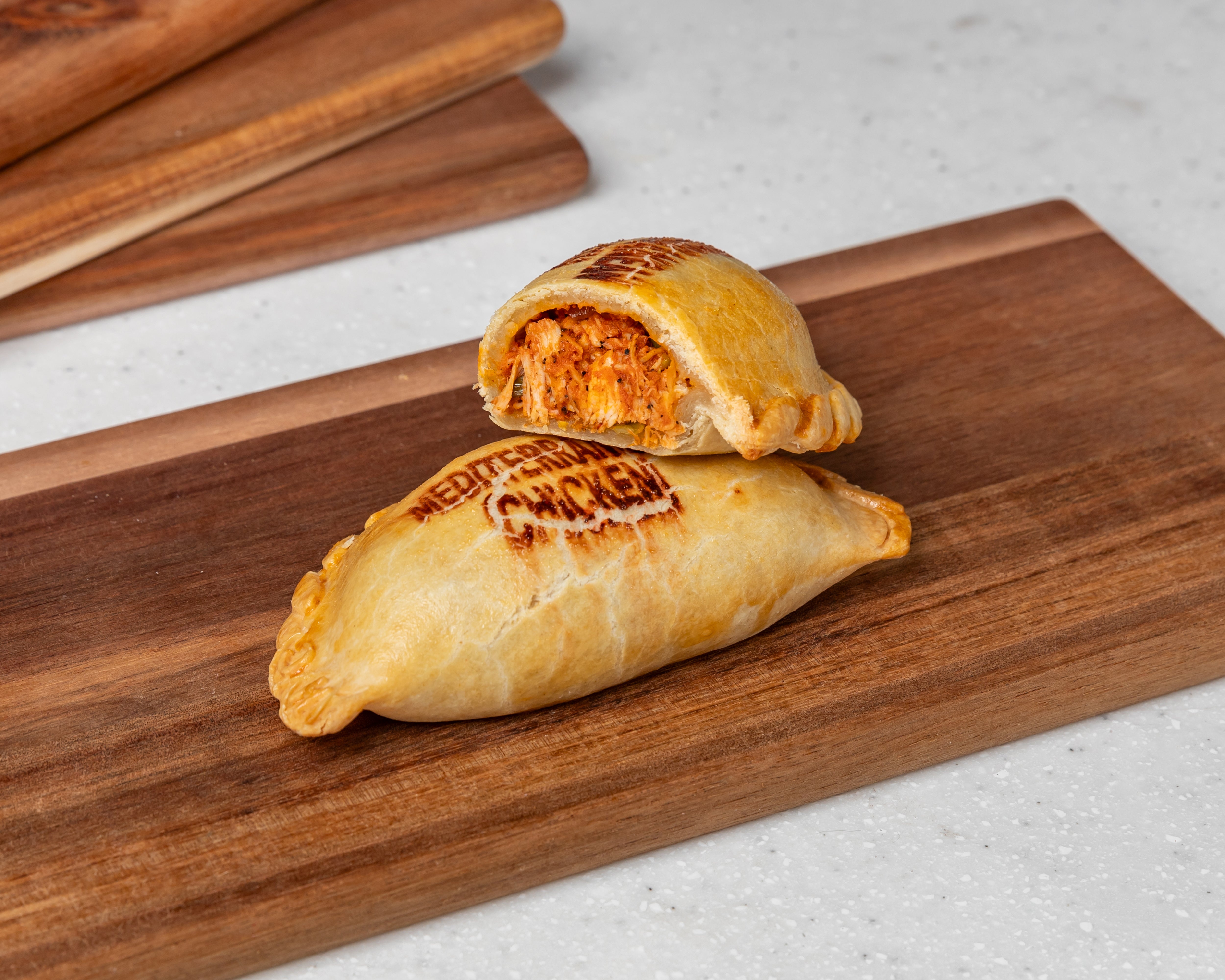 Mediterranean Chicken Empanada filled with shredded chicken, onions, peppers, mixed veggies, and tangy tomato sauce – golden pastry handmade by Cholito Empanadas in Sydney